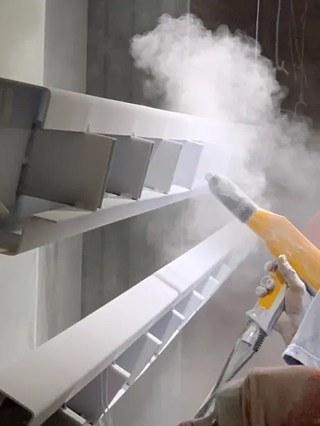 Proses penyemprotan powder coating pada komponen logam di spray booth